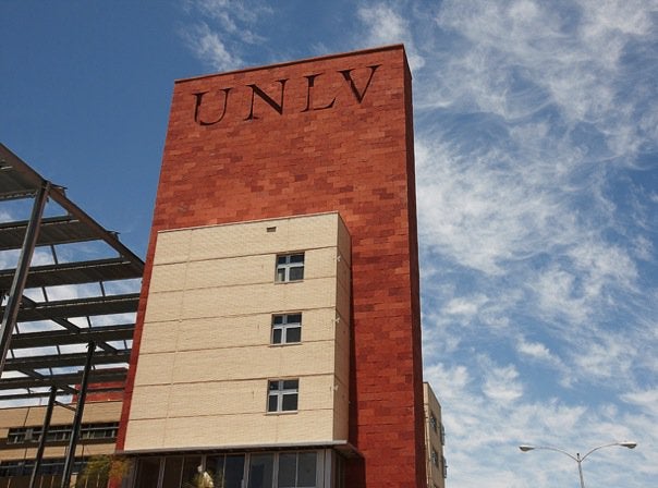 UNLV campus building with red brick tower and UNLV lettering against a blue sky