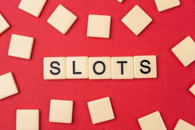 An image of the word "slots" spelled out in scrabble tiles