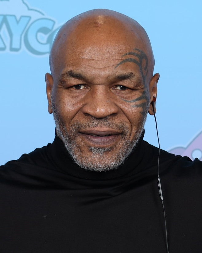 Mike Tyson smiling at a 2023 event, the boxer behind the new Iron Mike Legacy attraction at Flamingo Las Vegas