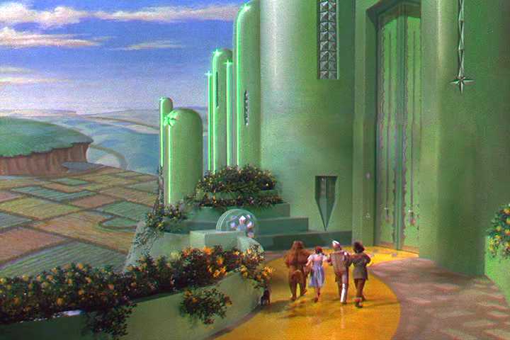 Wizard of Oz 2.0: Sphere's Upgraded Vegas Show Debuts Dorothy, Scarecrow, Tin Man, and Cowardly Lion walking toward the Emerald City in a scene from The Wizard of Oz
