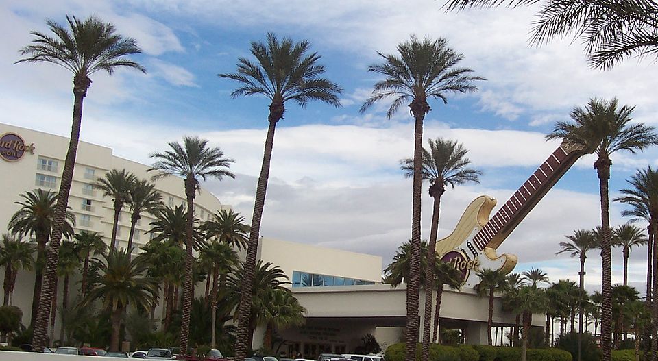 Exterior view of the Hard Rock Hotel & Casino Las Vegas featuring its iconic giant guitar sign and palm trees in Las Vegas