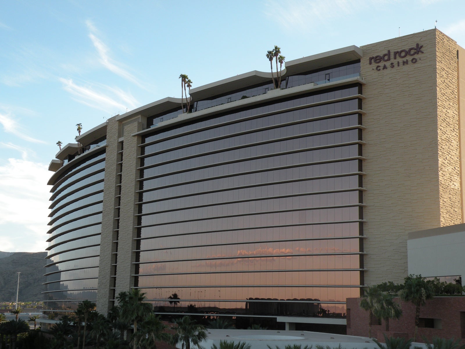 Red Rock Resorts Q2 2026 Results Beat Wall Street Estimates Exterior view of Red Rock Casino Resort in Las Vegas with curved glass facade at sunset